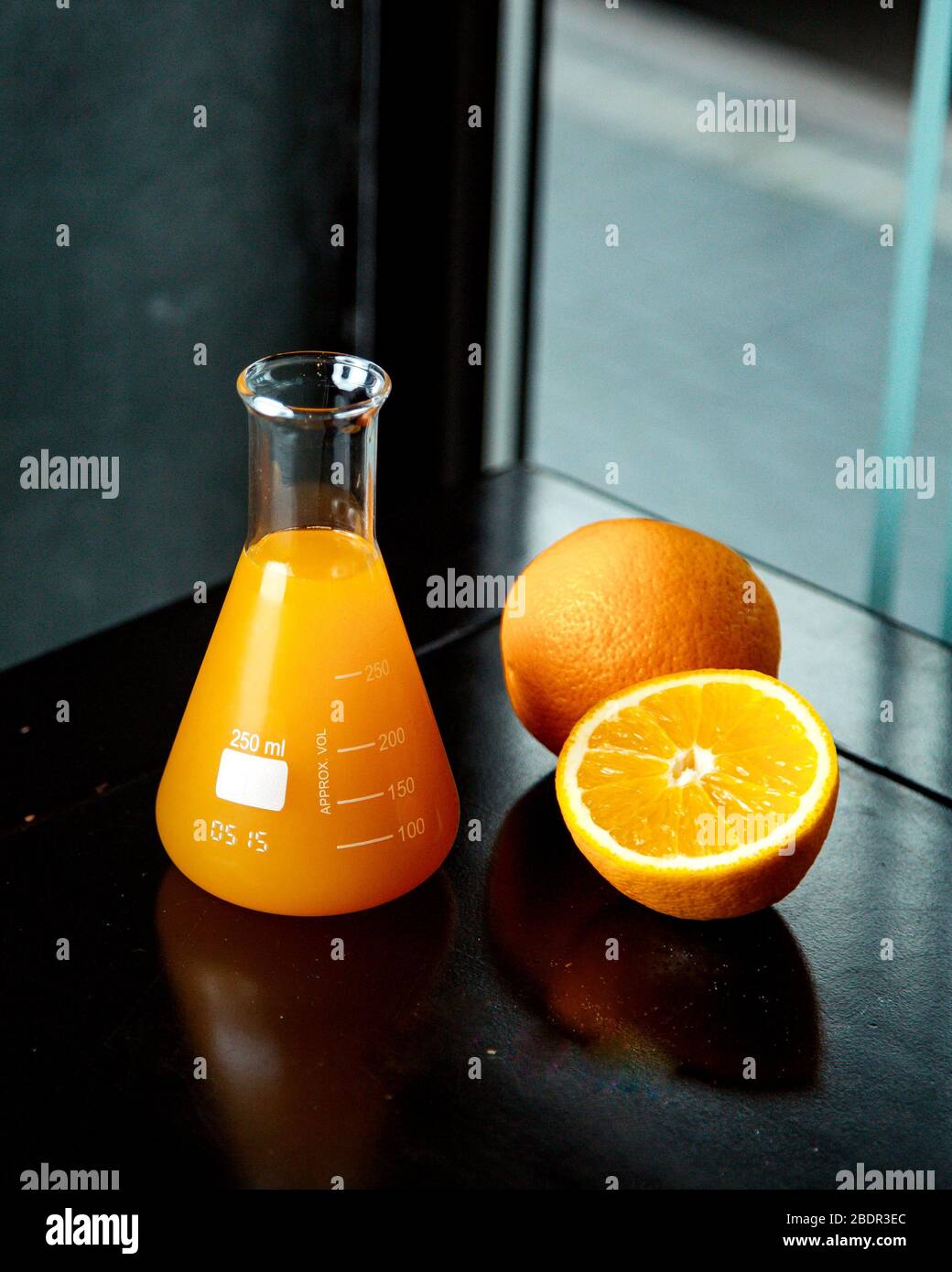 Orangensaft im Glas und frische Orange daneben Stockfoto