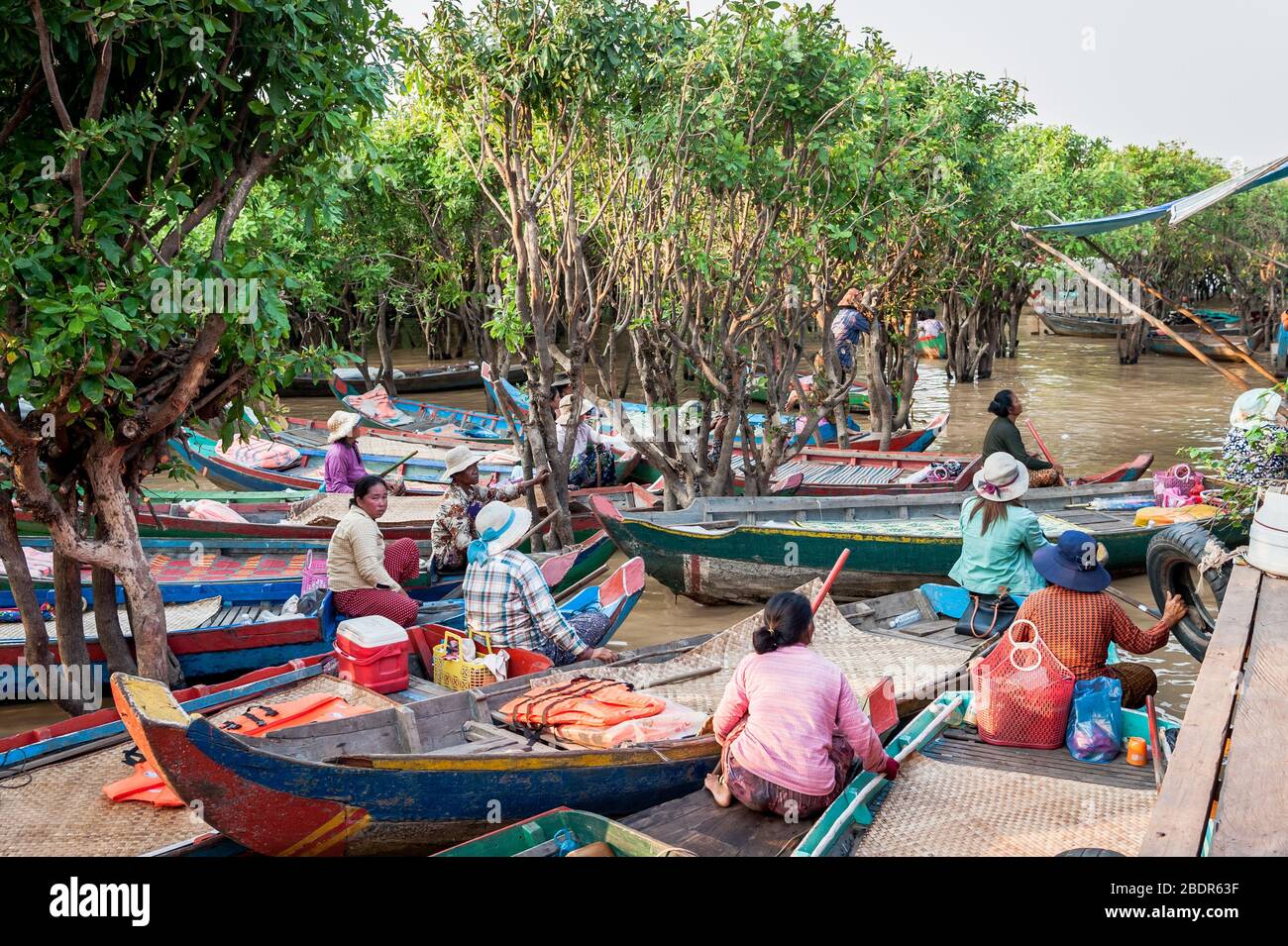 Einheimische Frauen laden Touristen zu einer Bootsfahrt durch die Sümpfe und Dschungelflüsse am Rande des Tonle SAP Sees, Kampong Phluk, Kambodscha ein. Stockfoto