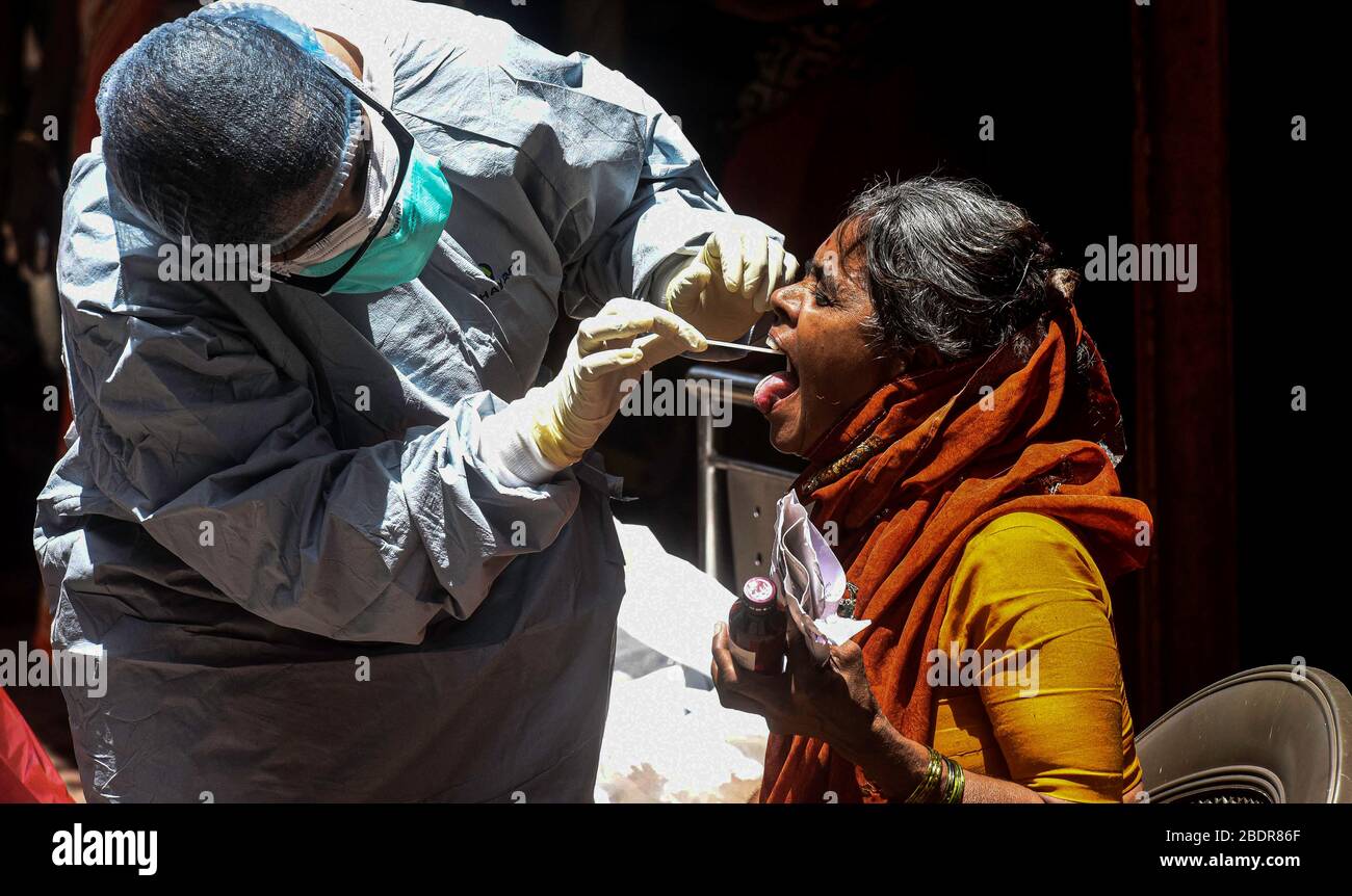 Mumbai, Indien. April 2020. Eine medizinische Fachkraft, die einen Schutzanzug trägt, nimmt einen Tupfer von einer Frau, um in einem Wohngebiet in Mumbai, Indien, am 9. April 2020 auf eine neuartige Coronavirus Krankheit zu testen. Indiens Gesundheitsministerium sagte am Donnerstagabend, dass die Zahl der Todesopfer aufgrund der COVID-19 in Indien auf 169 stieg und die Gesamtzahl der bestätigten Fälle im Land 5.865 erreichte. Kredit: Fariha Farooqui/Xinhua/Alamy Live News Stockfoto