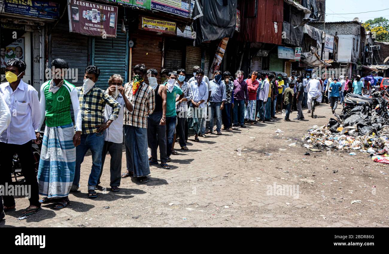 Mumbai, Indien. April 2020. Indische Leute warten in einem Wohngebiet in Mumbai, Indien, am 9. April 2020 in Reihe auf Lebensmittel. Indiens Gesundheitsministerium sagte am Donnerstagabend, dass die Zahl der Todesopfer aufgrund der COVID-19 in Indien auf 169 stieg und die Gesamtzahl der bestätigten Fälle im Land 5.865 erreichte. Kredit: Fariha Farooqui/Xinhua/Alamy Live News Stockfoto