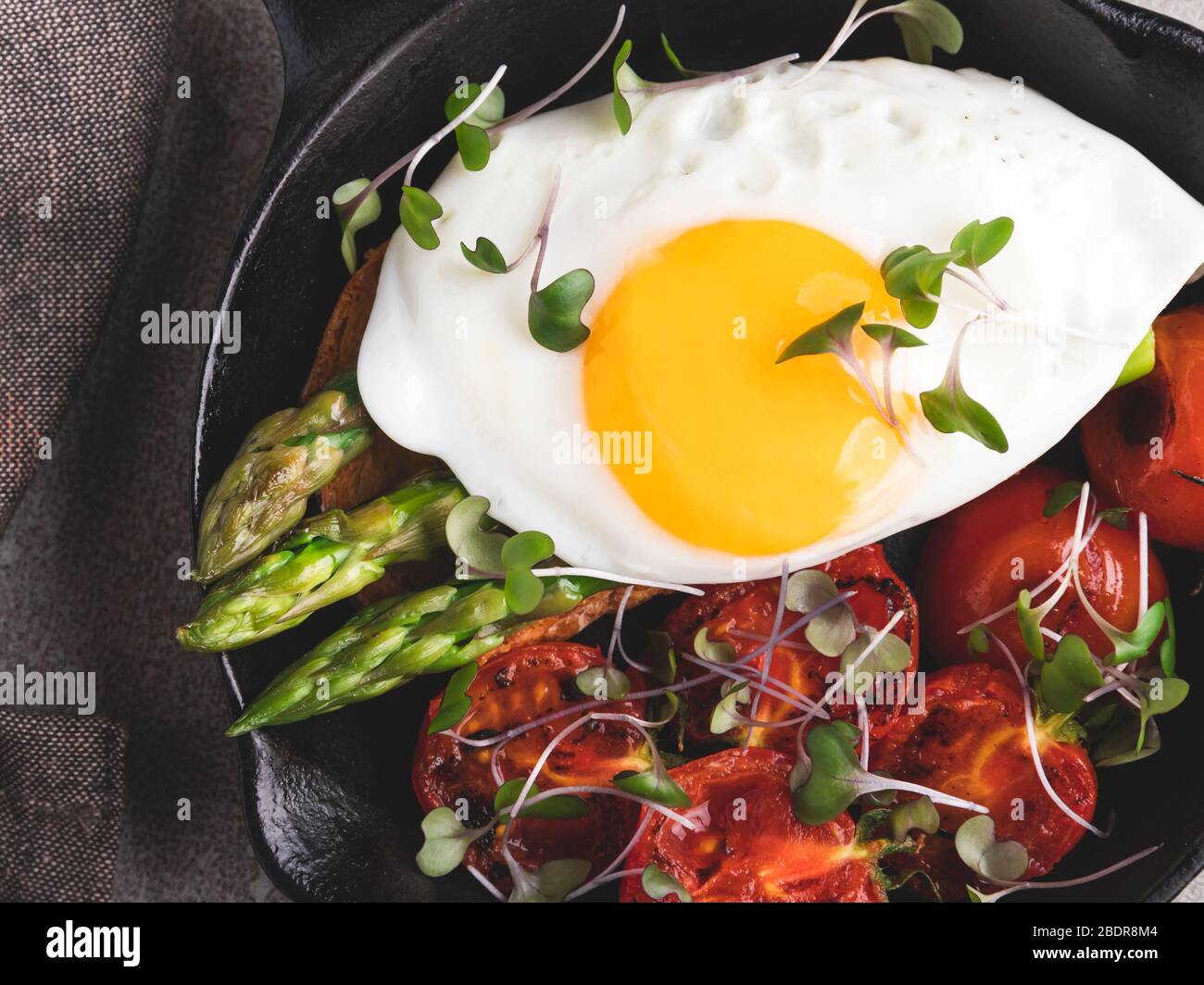 Spiegelei auf Toast mit gerösteten Tomaten Spargel Frühstück, gesunde Lebensmittel Nahaufnahme Stockfoto