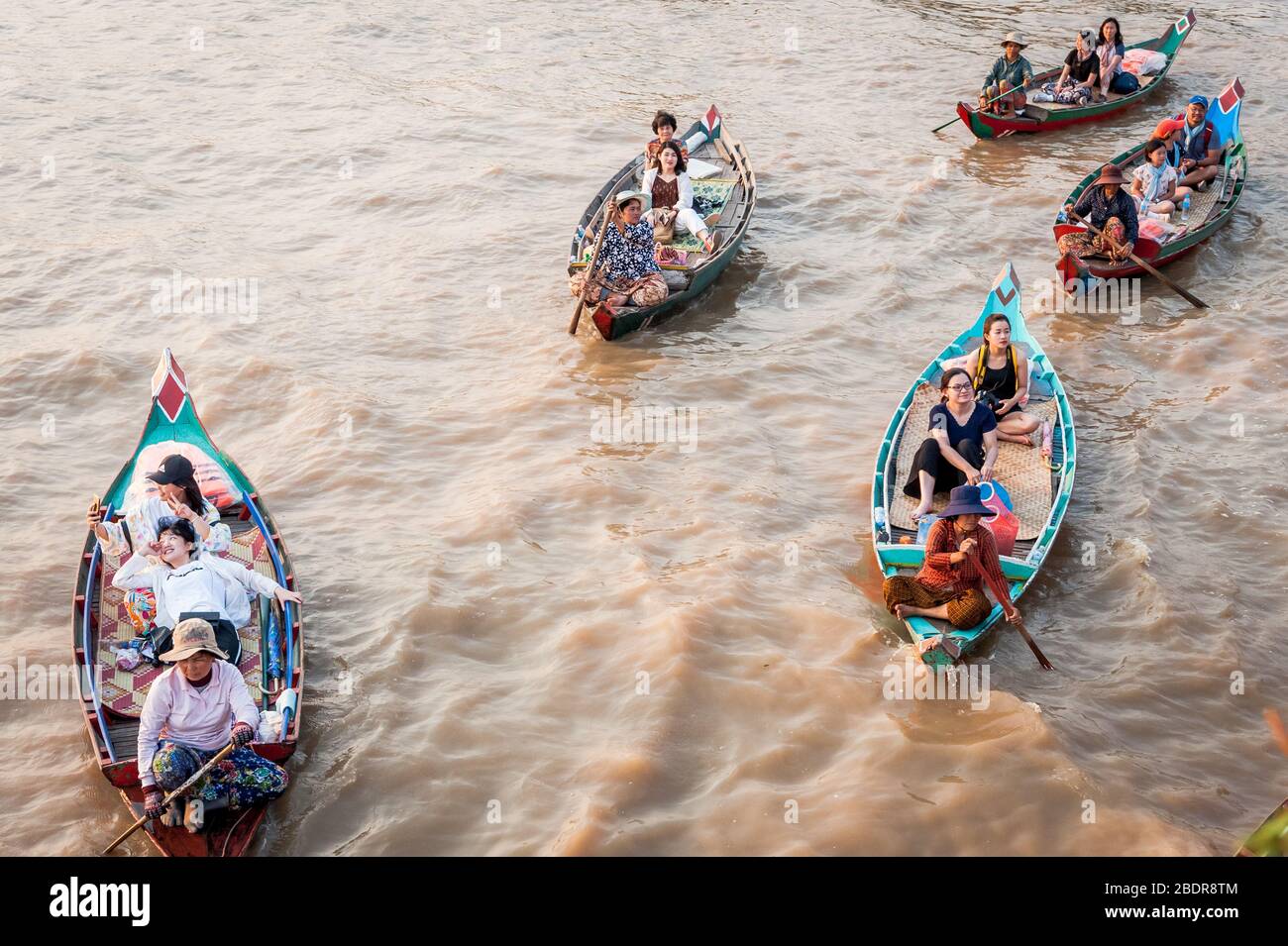 Einheimische Frauen laden Touristen zu einer Bootsfahrt durch die Sümpfe und Dschungelflüsse am Rande des Tonle SAP Sees, Kampong Phluk, Kambodscha ein. Stockfoto