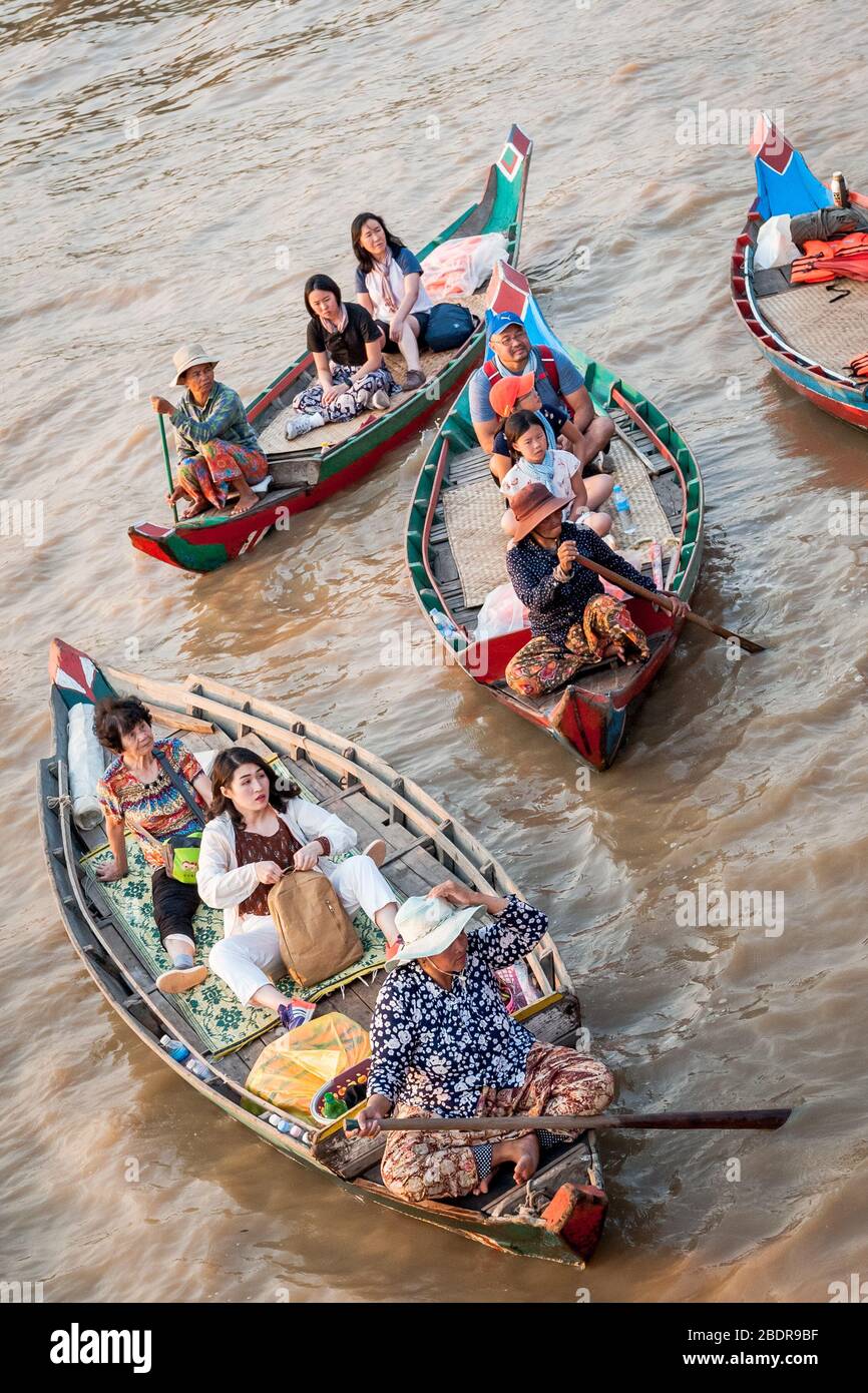 Einheimische Frauen laden Touristen zu einer Bootsfahrt durch die Sümpfe und Dschungelflüsse am Rande des Tonle SAP Sees, Kampong Phluk, Kambodscha ein. Stockfoto