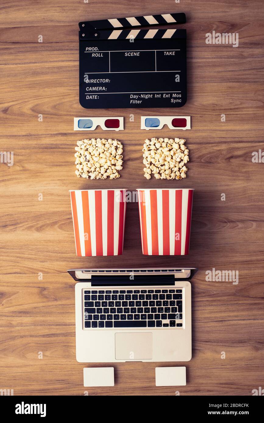 Laptop, Klappe, Popcorn und 3D-Brille: Kino streaming und Film online-Serienkonzept Stockfoto