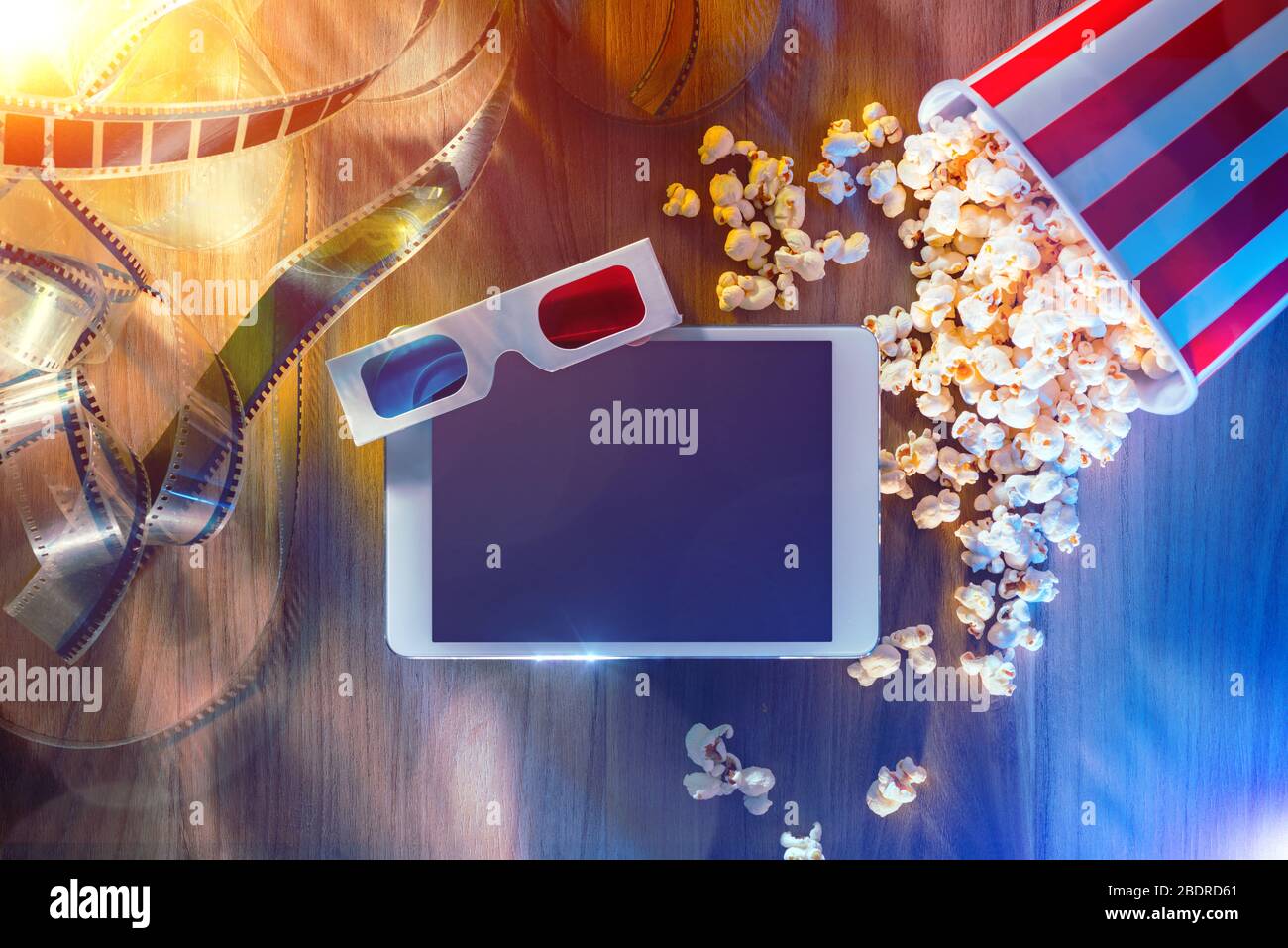 Digital Touch-Screen-Tablette mit Popcorn, 3D-Brille und Filmstreifen; Film Online-Streaming-Kino und Entertainment-Konzept Stockfoto