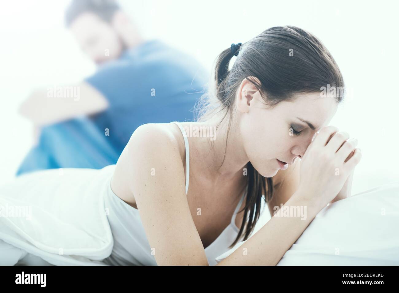 Junges Paar im Schlafzimmer mit Beziehungsschwierigkeiten und streiten, die Frau weint Stockfoto