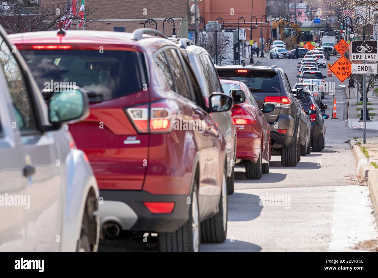 Detroit, Michigan, USA. April 2020. Während der Coronavirus-Krise verteilt die Gleaners Community Food Bank kostenlose Lebensmittel an bedürftige Bewohner im Südwesten Detroits. Eine lange Autofahrstrecke wartet auf den Zugang zum Verteilstandort. Kredit: Jim West/Alamy Live News Stockfoto