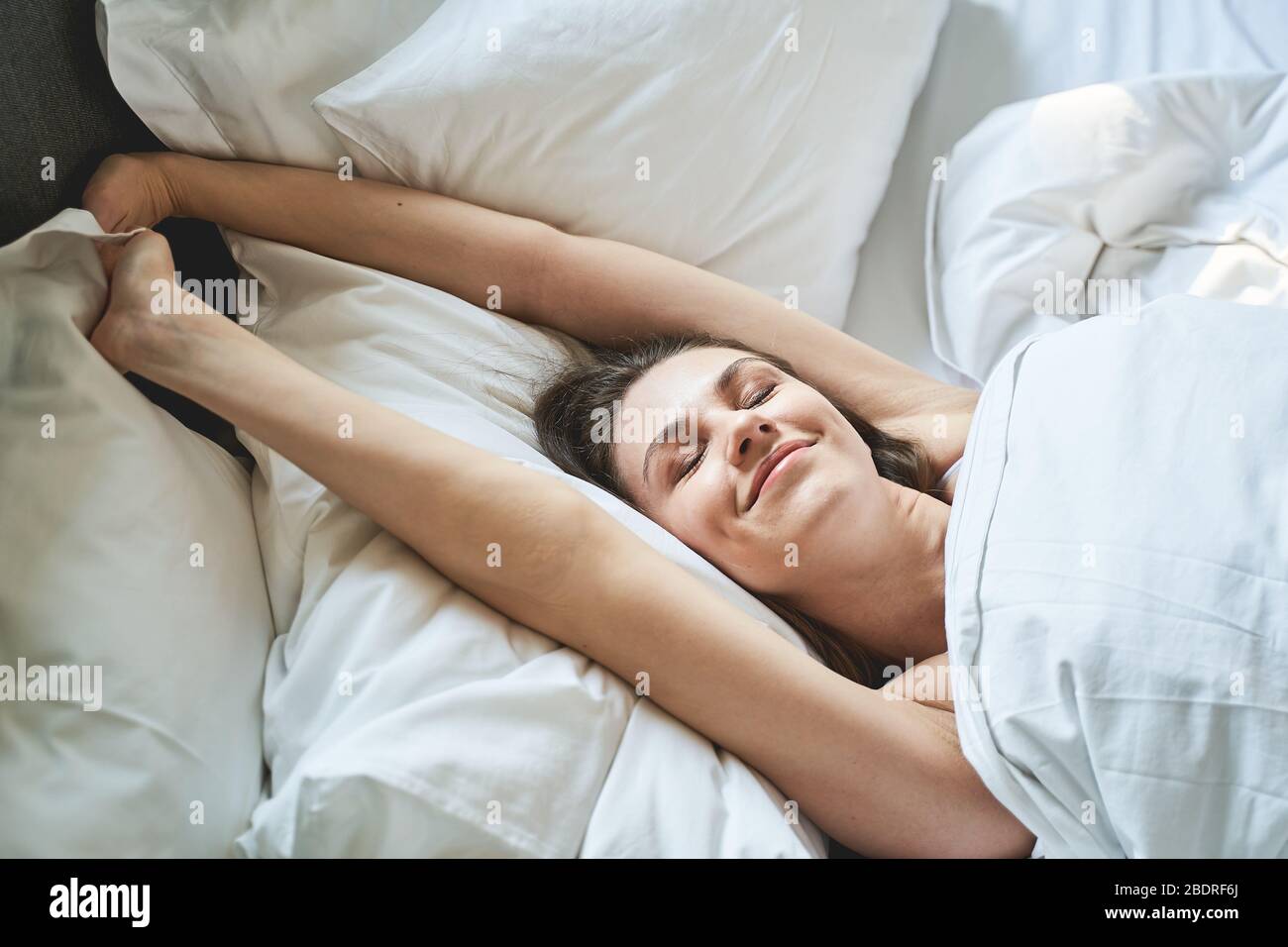 Mädchen mit geschlossenen Augen liegen in einem Schlafzimmer Stockfoto