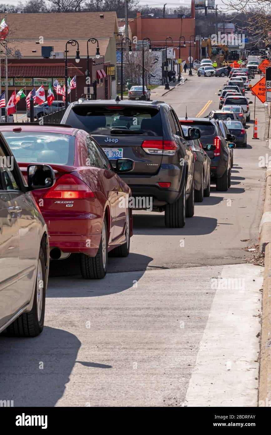 Detroit, Michigan, USA. April 2020. Während der Coronavirus-Krise verteilt die Gleaners Community Food Bank kostenlose Lebensmittel an bedürftige Bewohner im Südwesten Detroits. Eine lange Autofahrstrecke wartet auf den Zugang zum Verteilstandort. Kredit: Jim West/Alamy Live News Stockfoto