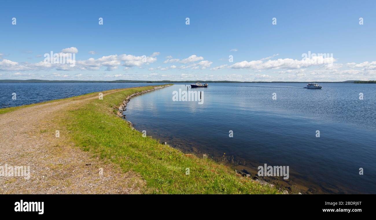 Wellenbrecher und ein kleiner Binnengewässer Fischtrawler ankerten dahinter am See Pohjois-Konnevesi, Finnland Stockfoto