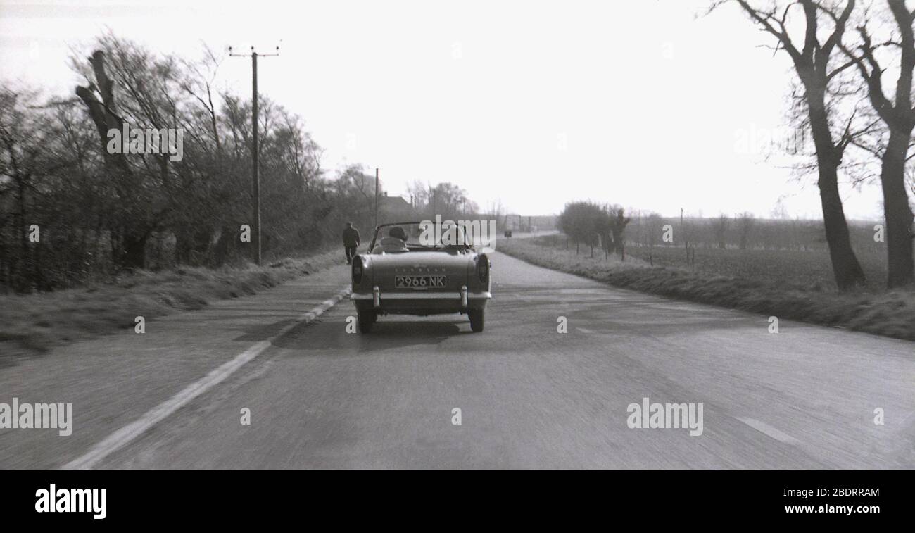 1960er, historisch, auf einer offenen Landstraße, ein zweisitziger Sunbeam Alpine Sportwagen oder Roadster von hinten gesehen, in der Nähe von Letchworth Garden City, Herts, England, Großbritannien. Stockfoto