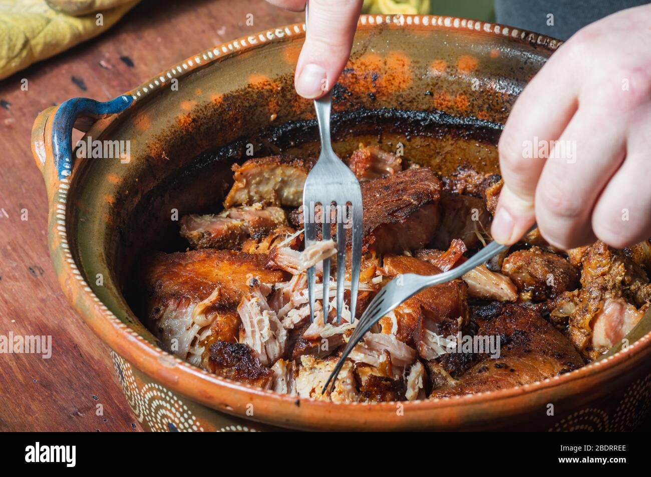 Mexikanische Carnitas. Männliche Hände Shredding langsam gekochten Schweinefleisch Carnitas, im Stil von Michoacan Stockfoto