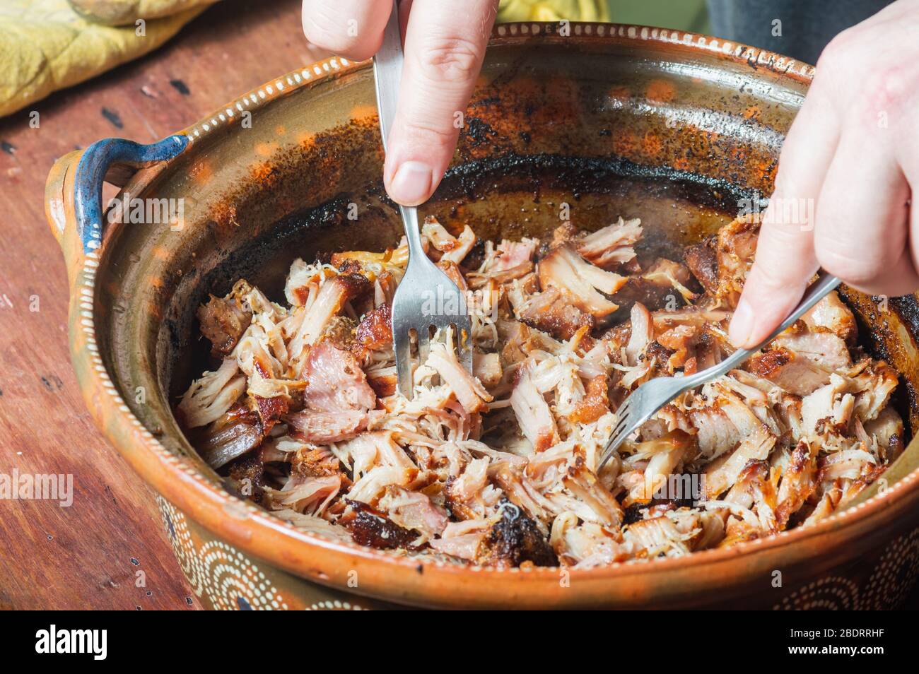 Mexikanische Carnitas. Männliche Hände Shredding langsam gekochten Schweinefleisch Carnitas, im Stil von Michoacan Stockfoto