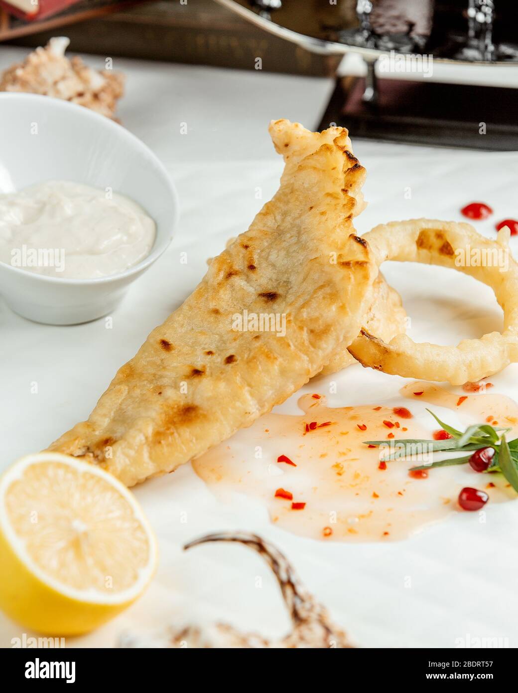 Knusprig gebratener Fisch und Calamari mit Mayonnaise und Zitrone serviert Stockfoto