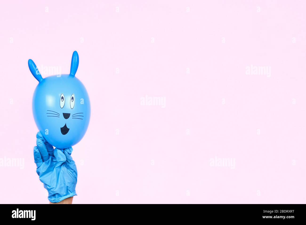 Weibliche Hände in medizinisch-chirurgischen Handschuhen halten niedlichen Osterhase. Ostern 2020 in Quarantäne während der COVID-19 Pandemie. Feiern Sie Easte Stockfoto