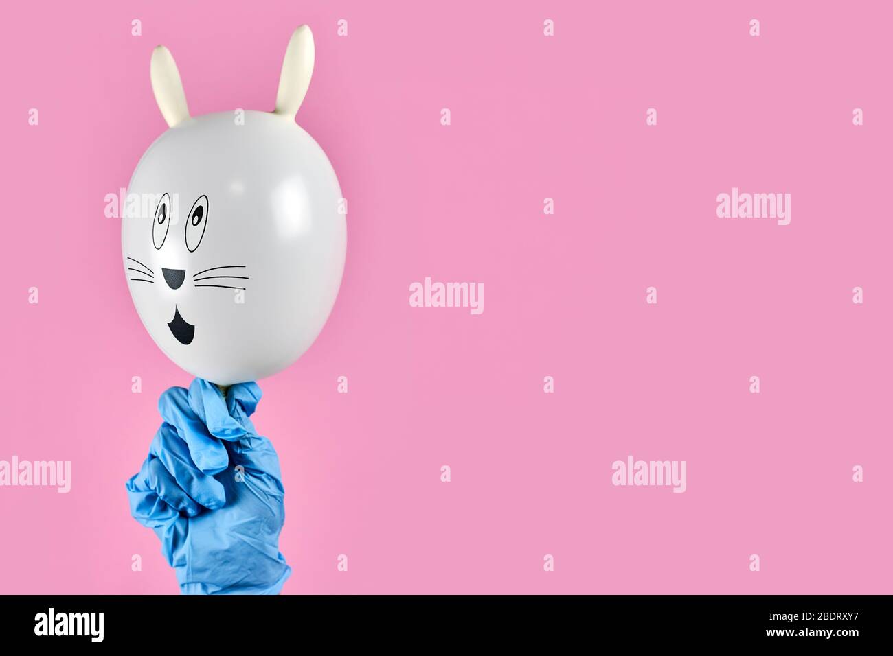 Weibliche Hände in medizinisch-chirurgischen Handschuhen halten niedlichen Osterhase. Ostern 2020 in Quarantäne während der COVID-19 Pandemie. Feiern Sie Easte Stockfoto