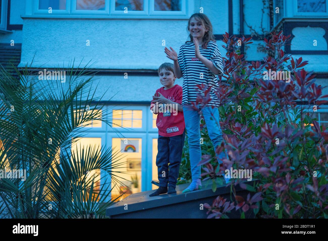 London, Großbritannien. Donnerstag, 9. April 2020. Kinder auf einer Straße in Ealing halten um acht Uhr an, um NHS-Arbeiter und Pfleger zu applaudieren (Foto mit elterlicher Genehmigung). Foto: Roger Garfield/Alamy Live News Stockfoto