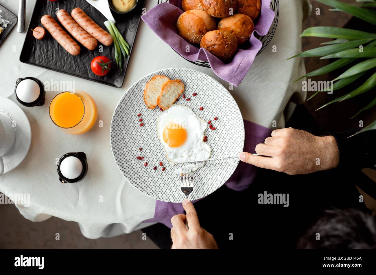 Blick von oben auf den Mann, der das Frühstück mit einem sonnigen Ei serviert Stockfoto