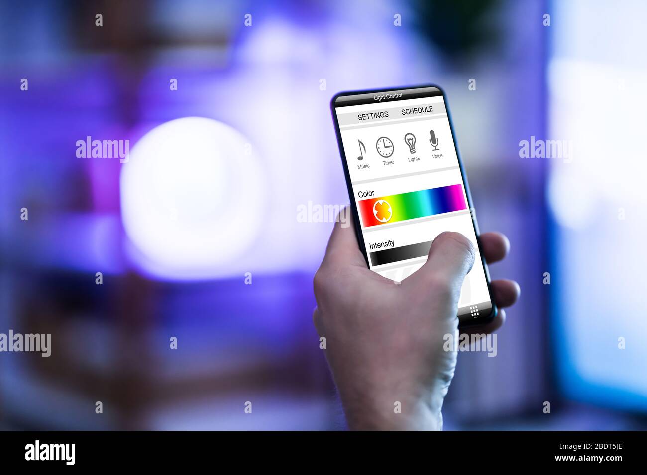 Person Steuerung von Licht mit App auf Telefon Stockfoto