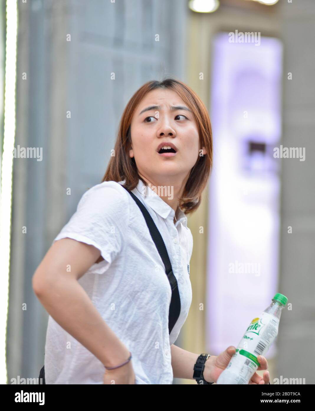 Chinesische junge Frau, die verwirrt in der Jianghan Straße, Wuhan, China, aussahen Stockfoto