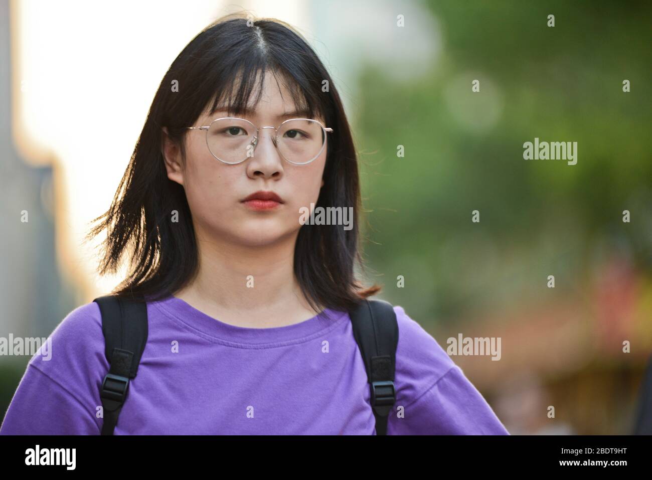 Chinesische junge Frau, die ernsthaft in der Jianghan Road, Wuhan, China aussieht Stockfoto