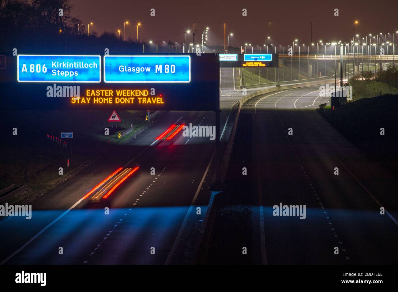 Glasgow, Großbritannien. April 2020. Abgebildet: Straßenschilder entlang der Autobahnen M8 und M80, die lauten: "EASTER WEEKEND STAY HOME DONT TRAVEL" die Pandemie von Coronavirus hat die britische Regierung gezwungen, eine Abschaltung aller britischen Großstädte zu bestellen und die Menschen zu Hause zu lassen. Das hat die Autobahnen und alle anderen Straßen frei von der üblichen Nase gelassen, um den Verkehr, der sonst da wäre, zu vereitelen. Kredit: Colin Fisher/Alamy Live News Stockfoto