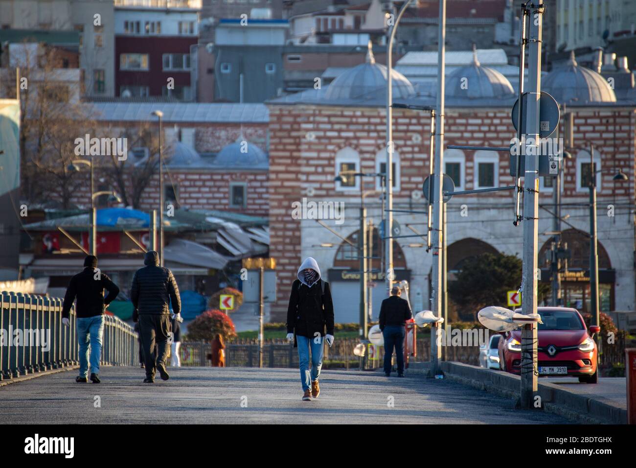 7. April 2020: Maskierte Bürger, die am 3. April 2020 auf der normalerweise recht überfüllten Galata-Brücke in der Nähe des Stadtteils Eminonu, Istanbul, TÜRKEI, spazieren gehen. Türkische Beamte haben die Bürger wiederholt aufgefordert, zu Hause zu bleiben und die sozialen Distanzierungsregeln zu respektieren. Die Türkei setzt weiterhin Maßnahmen zur Eindämmung der Verbreitung des Virus und zur Vermeidung einer vollständigen Sperrung ein, indem sie für alle Personen unter 60 Jahren und unter 20 Jahren Hausbestellungen ausgibt, Straßengrenzen von 31 Städten schließt, Bars schließt, Cafés und Restaurants und die Einschränkung öffentlicher Versammlungen.die Türkei bestätigte am 7. April 3.892 neue Coronavirus-Infektionen, Stockfoto