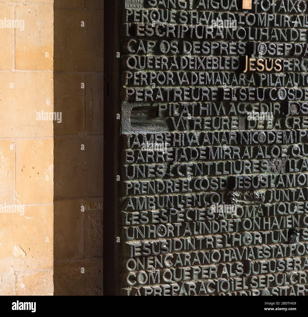 Bronzetür mit biblischem Text an der Passionsfassade der Basilika La Sagra Familia, Barcelona, Spanien . Stockfoto