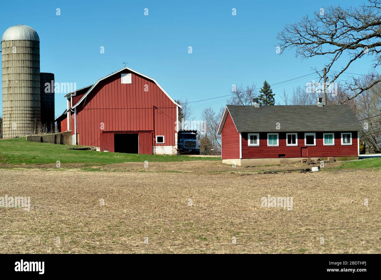 Elgin, Illinois, USA. Eine rote Scheune setzt zwischen Strukturen auf einem kleinen Bauernhof im Nordosten von Illinois. Stockfoto