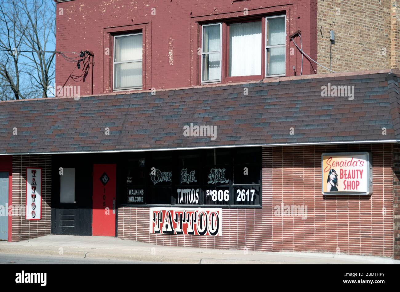South Elgin, Illinois, USA. Ein zweistöckiges Geschäft Front bietet ein Zuhause für ein Tattoo-Salon und Schönheitssalon entlang einer Hauptstraße in einer kleinen Vorstadt. Stockfoto