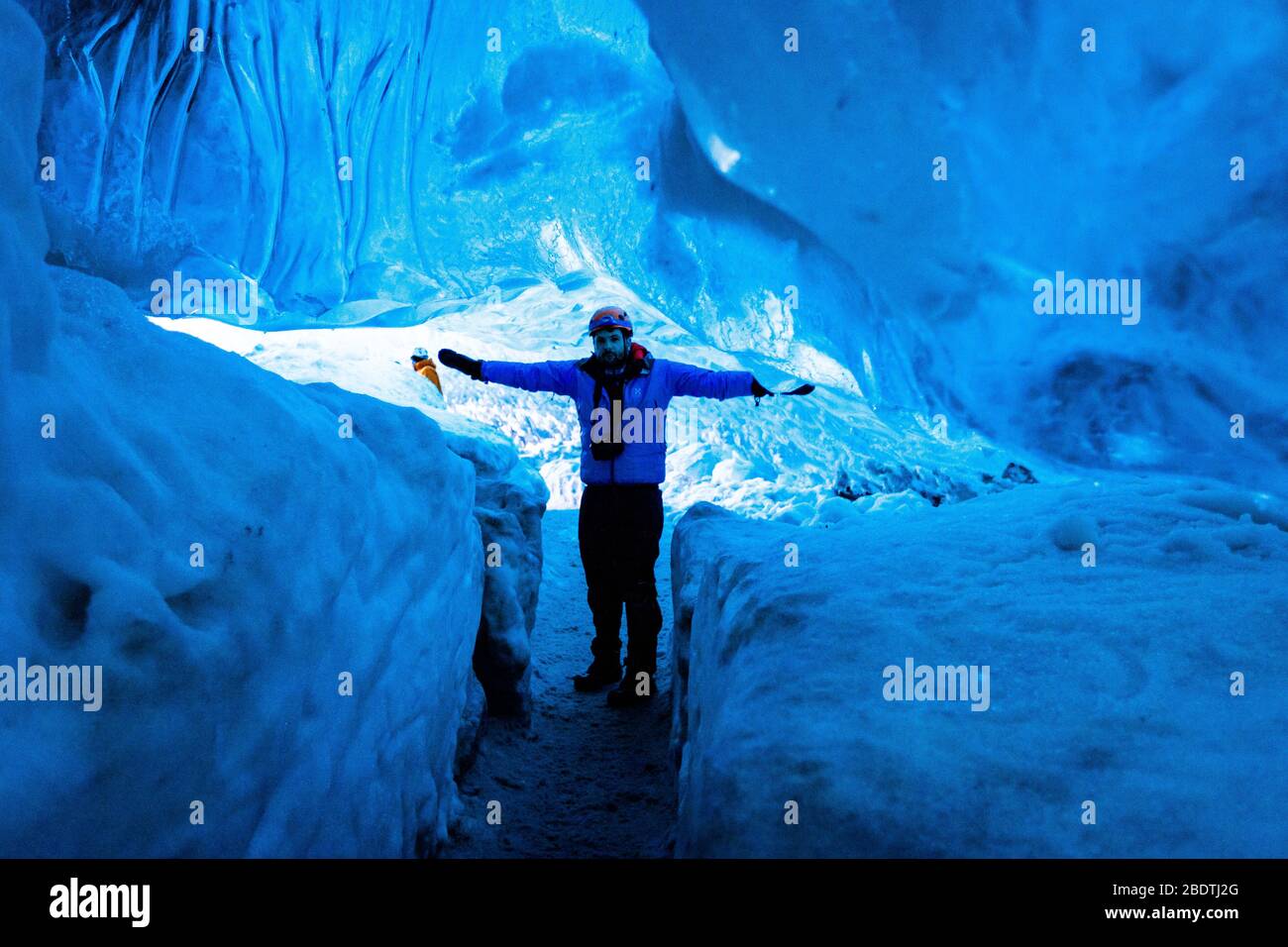 Ein männlicher Entdecker in einer Gletschereishöhle, Island Stockfoto