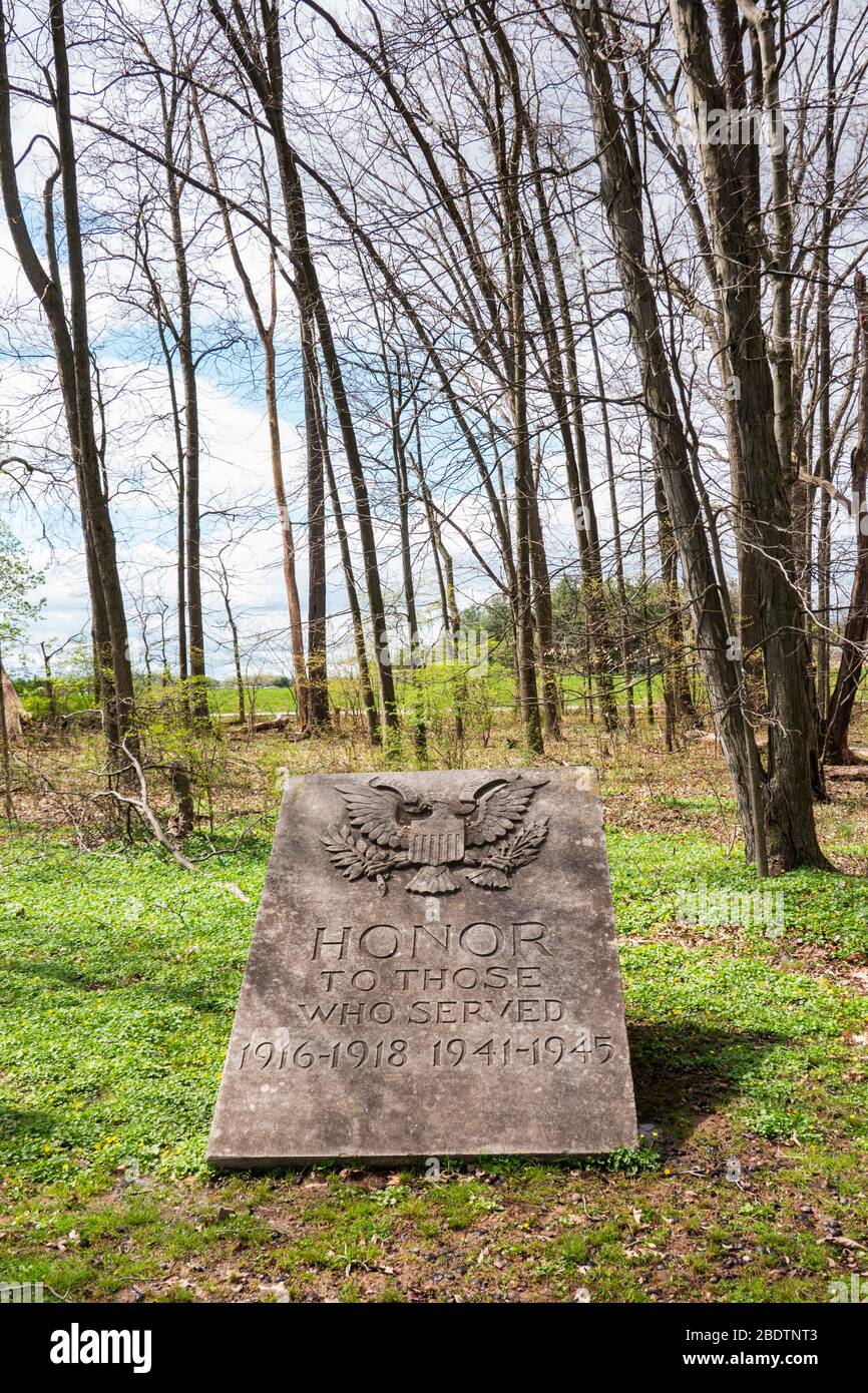 Worcester, PA - 8. April 2020: Dieses Steindenkmal sagt "Ehre denen, die 1916-1918 1941-1945 gedient haben" und sitzt inmitten des Waldes nahe dem Pavillon in Hee Stockfoto