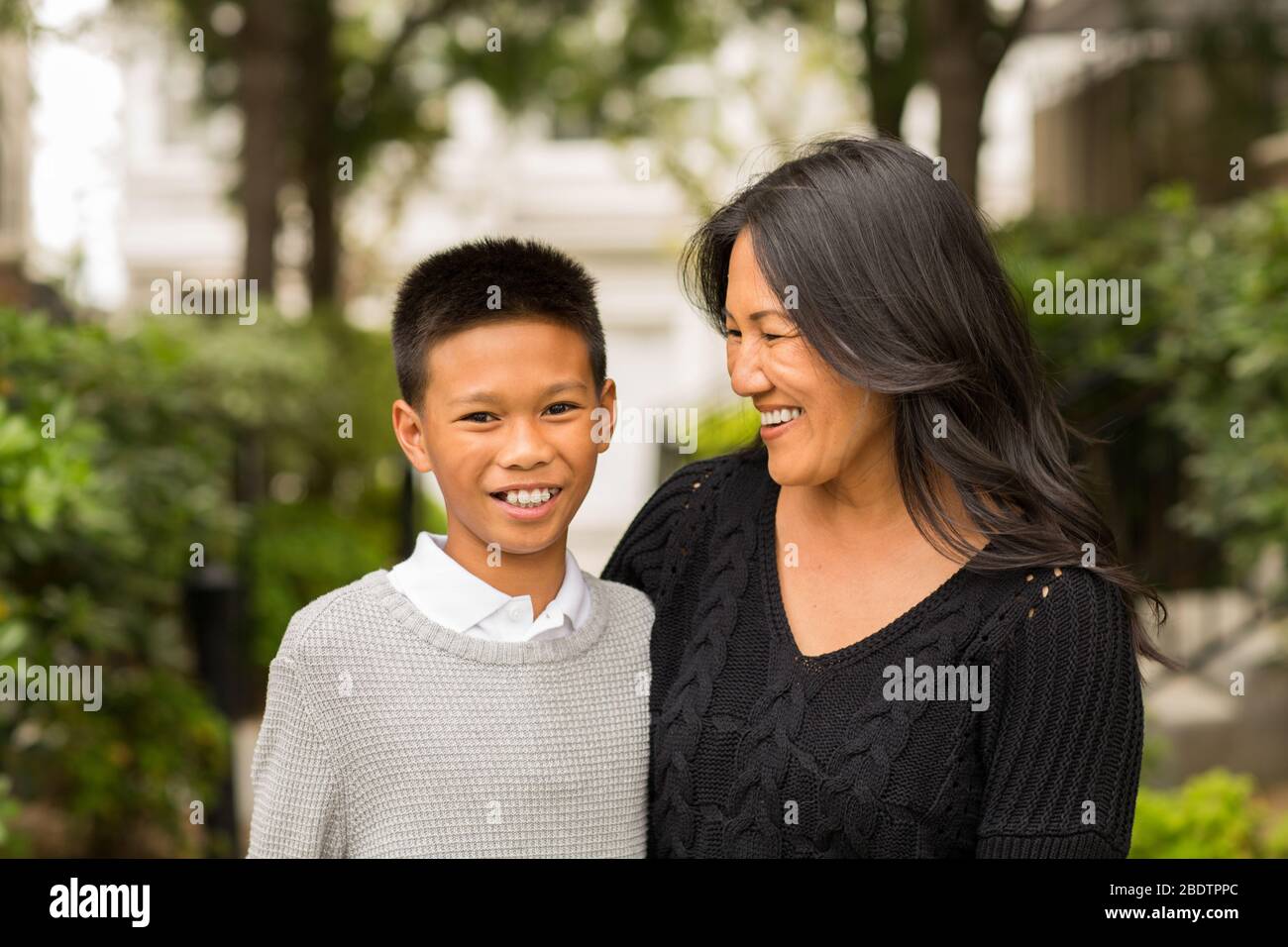 Asiatische Mutter lächelnd und umarmt sie Sohn. Stockfoto