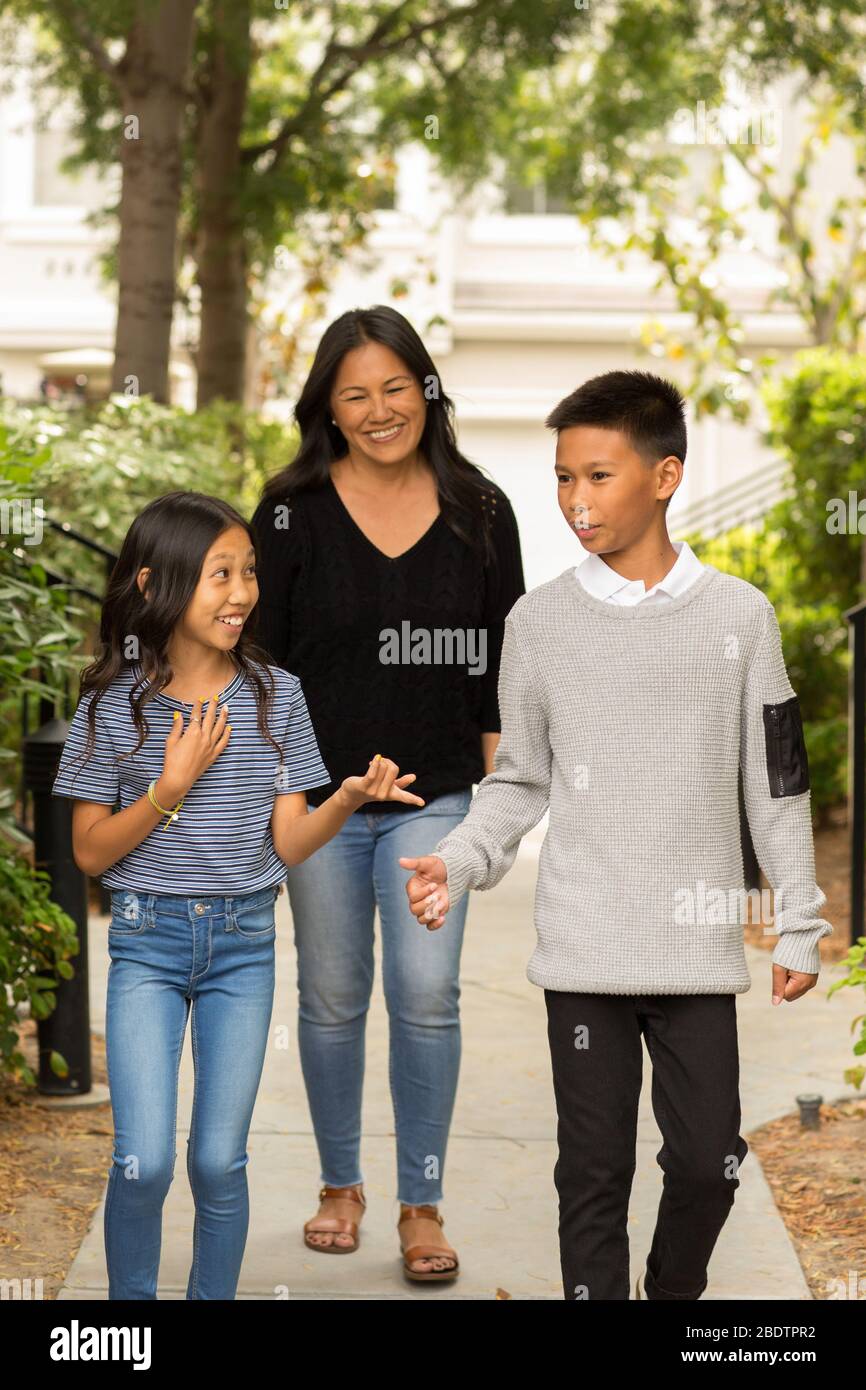 Asiatische Mutter lächelt und umarmt ihre Kinder. Stockfoto