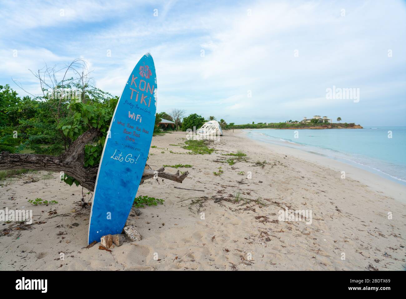 St. John, Antigua / Antigua & Barbuda - 18. Sep 2019: Surfbrett am Strand mit Text von Kontiki Floating Bar and Grill Stockfoto