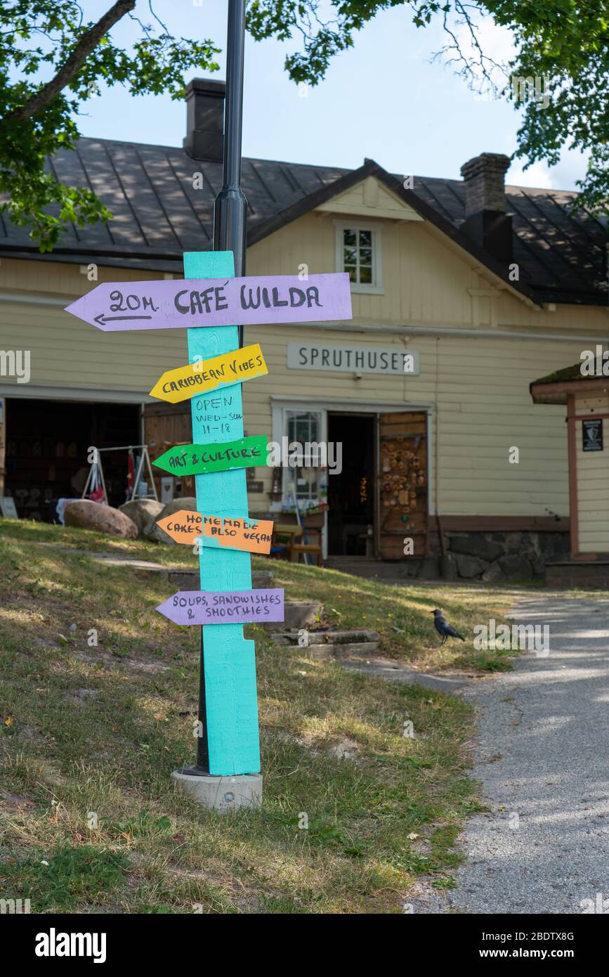 Ekenas, Vastra Nyland / Finnland - Juli 2019: Selbstgemachtes Schild, das in Richtung Café und andere lokale Einrichtungen zeigt Stockfoto