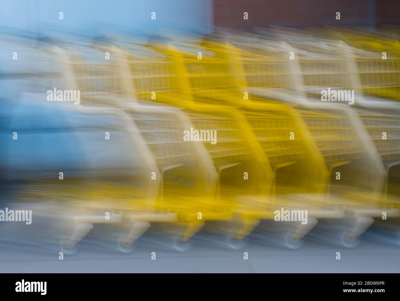 Moving Yellow and White Grocery Store Shopping Carts in Motion erfasst durch Slow Shutter und Kamera Bewegungsgeschwindigkeit Einkaufen oder eilen Eile Stockfoto