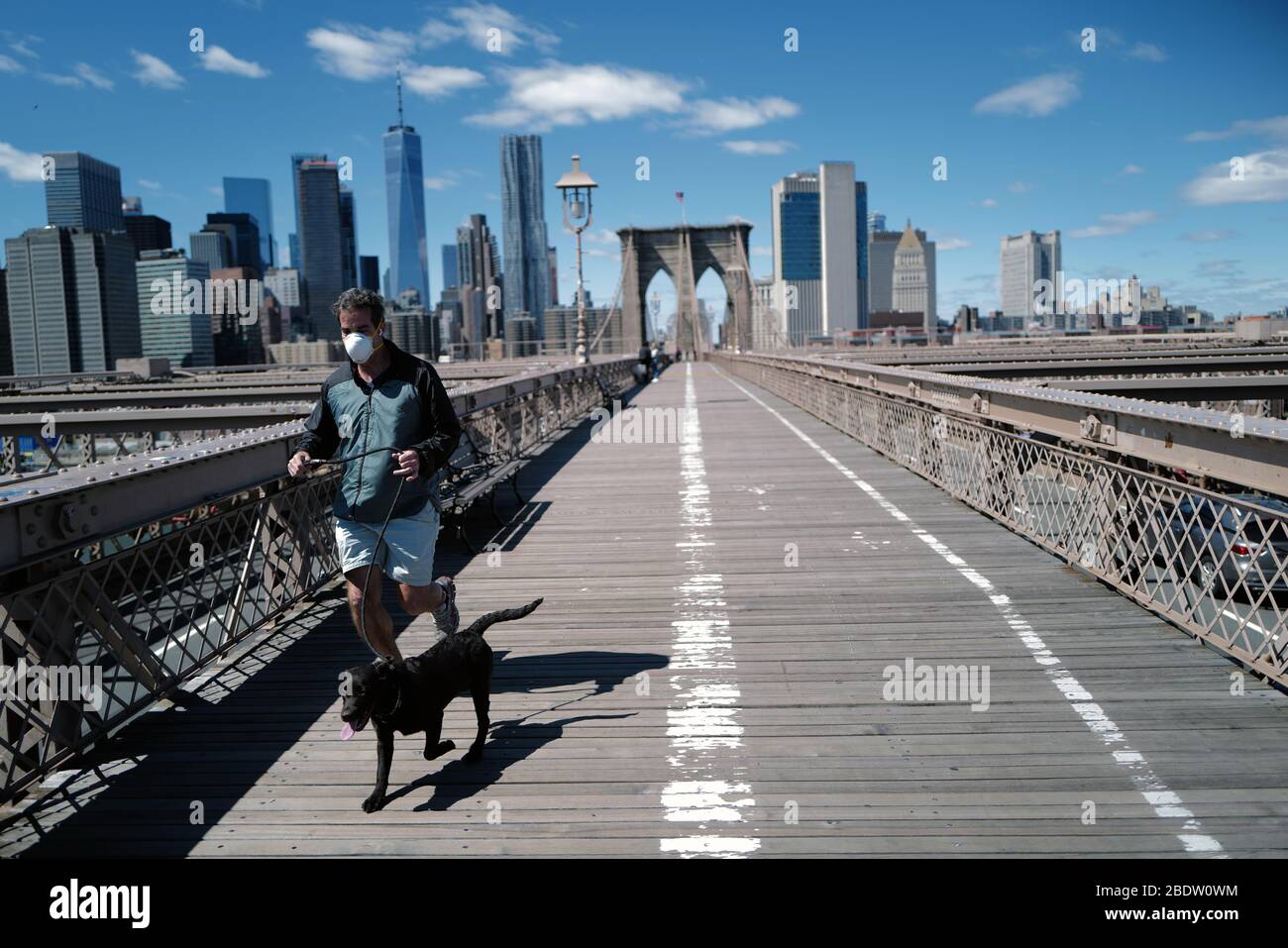 Der Mann joggt mit Maske an der Brooklyn Bridge während der Covid-19 Corona Virus Pandemie Stockfoto