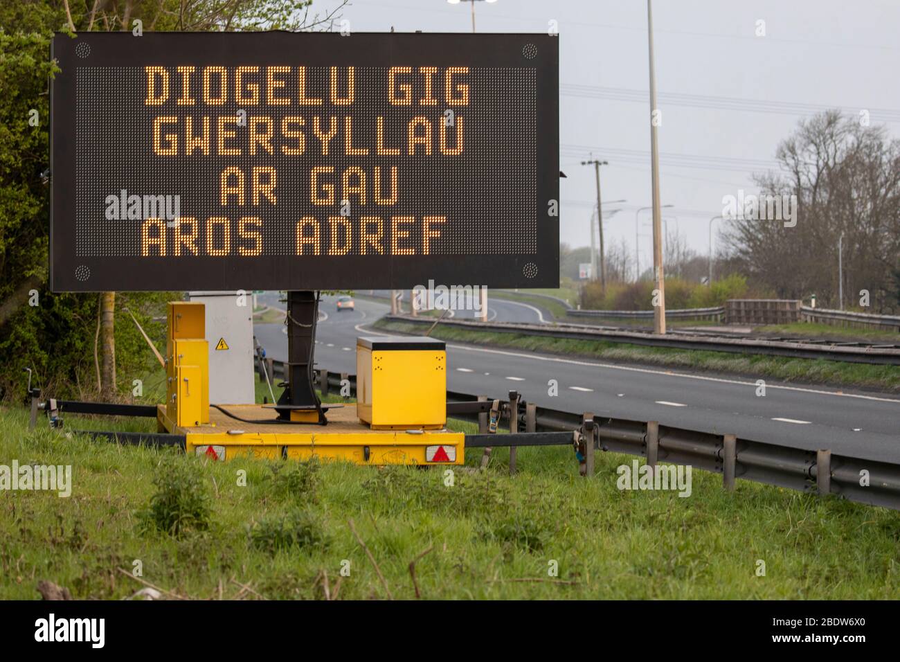 Flintshire, North Wales, 10. April 2020. UK Wetter: Verlassen A55 in Halkyn an einem heißen Feiertagswochenende und Karfreitag bis zu Reisebeschränkungen für Covid 19 Virus Sperrung. Ein walisisches Straßenwarnschild mit der Aufschrift ' SCHUTZ der NHS-SICHERHEIT, CAMPINGPLÄTZE GESCHLOSSEN' © DGDImages/AlamyLiveNews Stockfoto