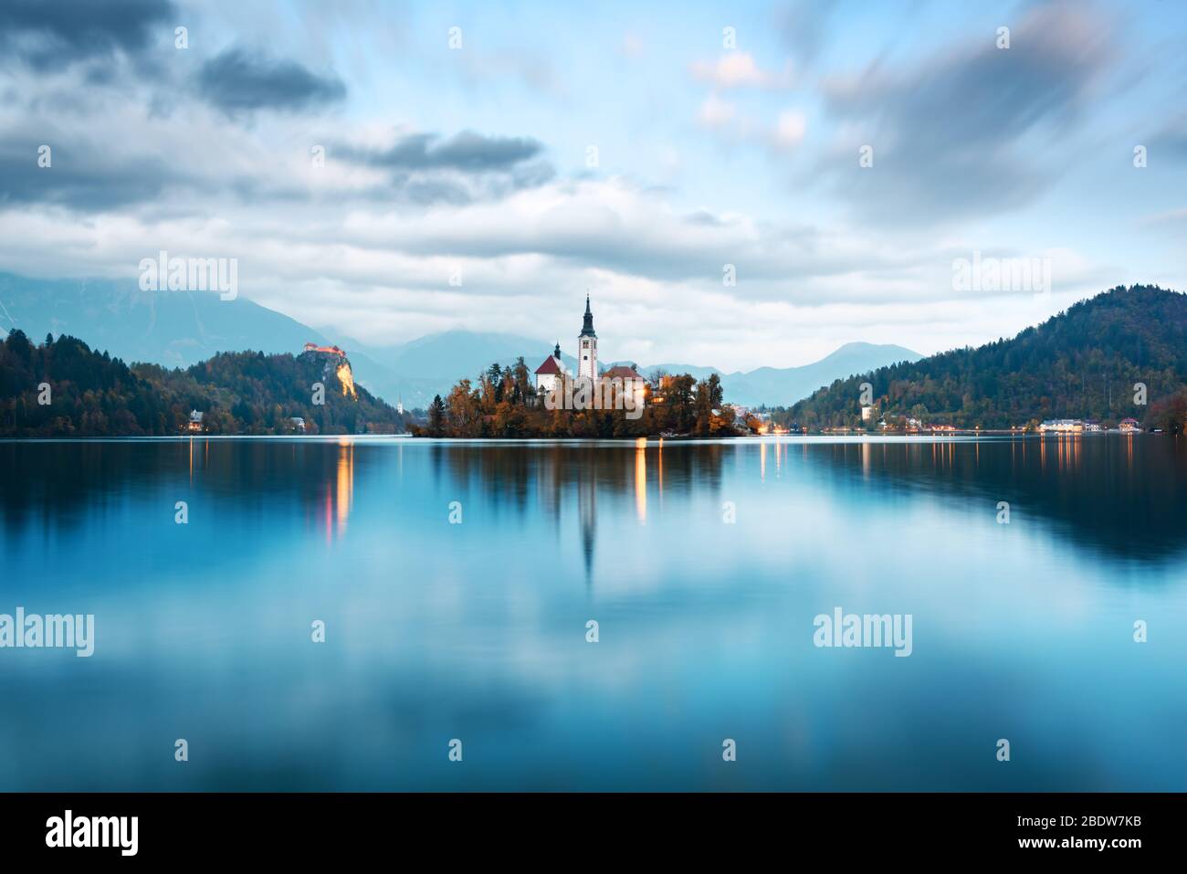 Abend herbst Blick auf See von Bled in den Julischen Alpen, Slowenien. Wallfahrtskirche der Himmelfahrt der Maria im Vordergrund. Landschaftsfotografie Stockfoto