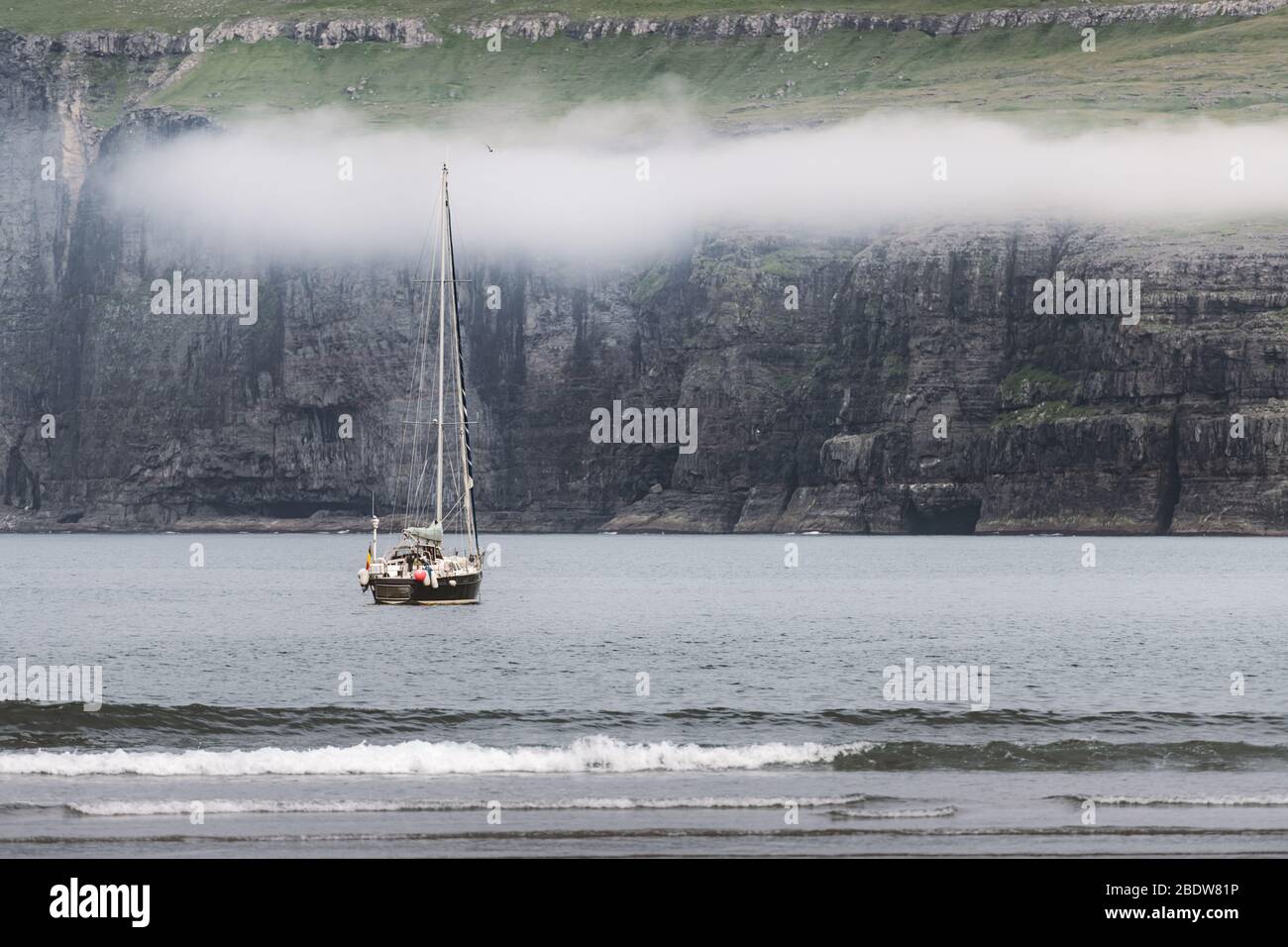 Einsame Yacht in der Nähe der Küste von Tjornuvik auf der Insel Streymoy, Färöer. Landschaftsfotografie Stockfoto