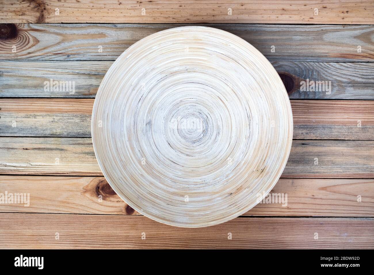 Runde Bambusplatte auf einem Holztisch Nahaufnahme. Food Fotografie Hintergrund Stockfoto