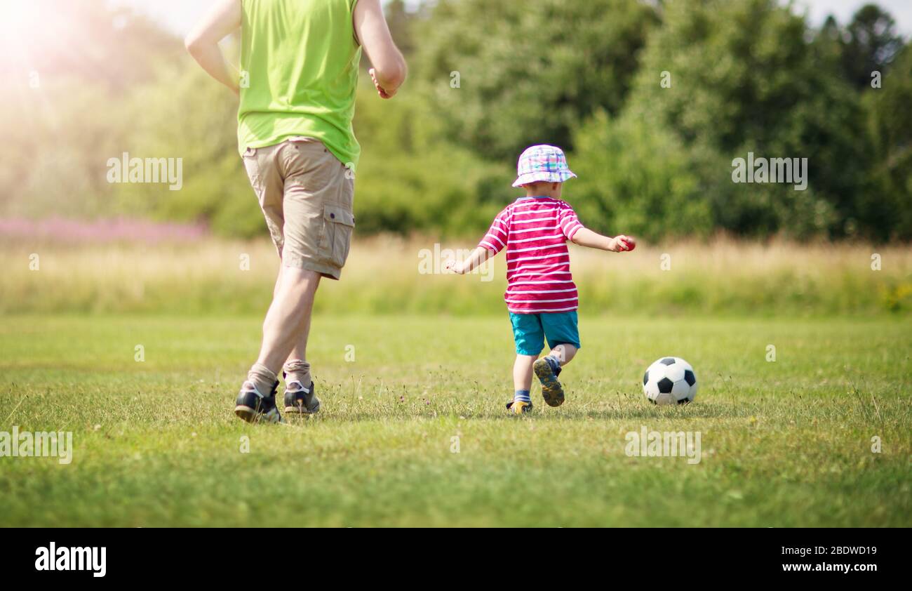 Kleiner Junge, der mit Toren Fußball auf dem Feld spielt Stockfoto