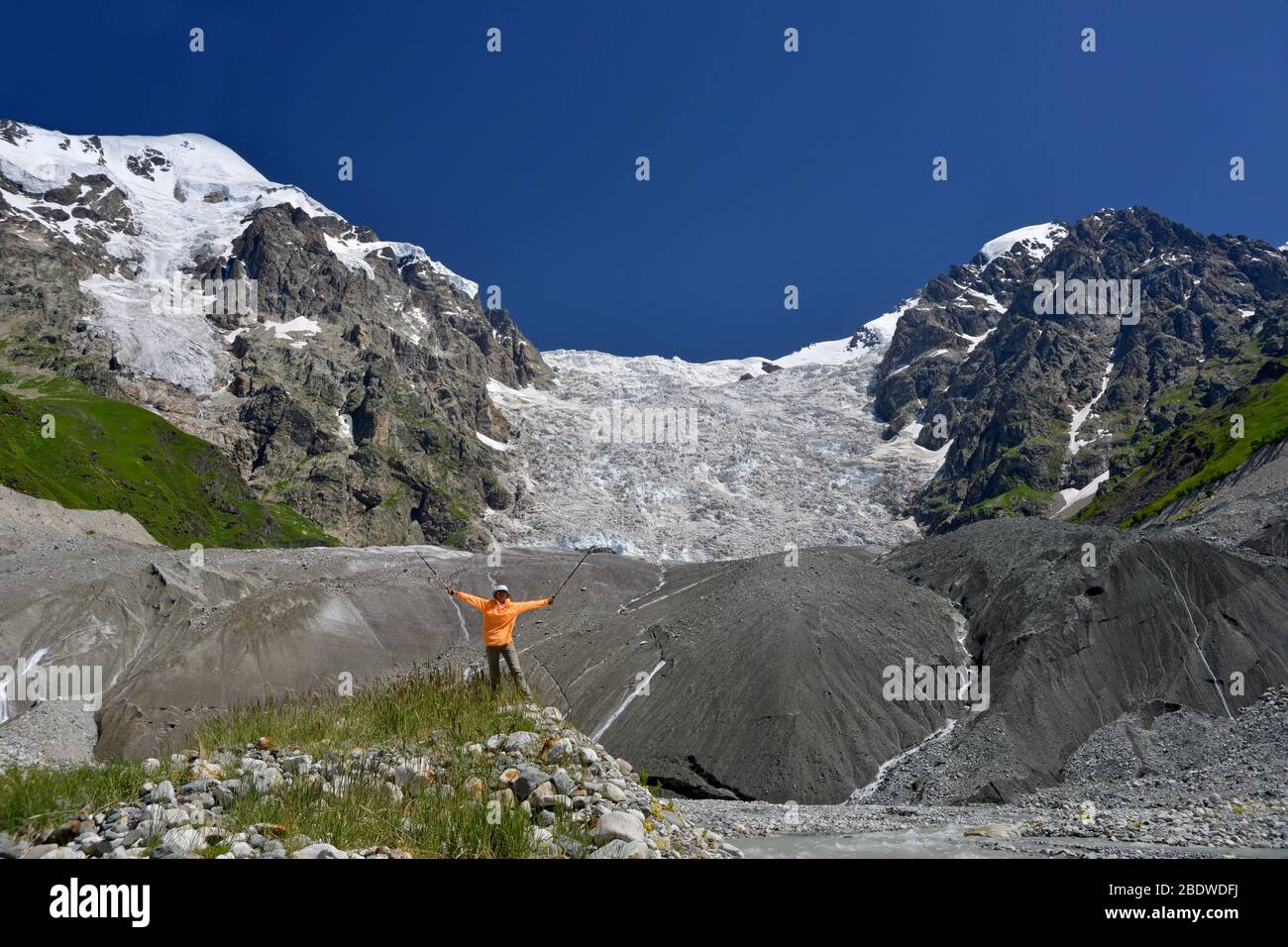 Fröhlicher Tourist vor großem Eisfall Hintergrund. Sommer klaren Tag und schöne Natur. Stockfoto