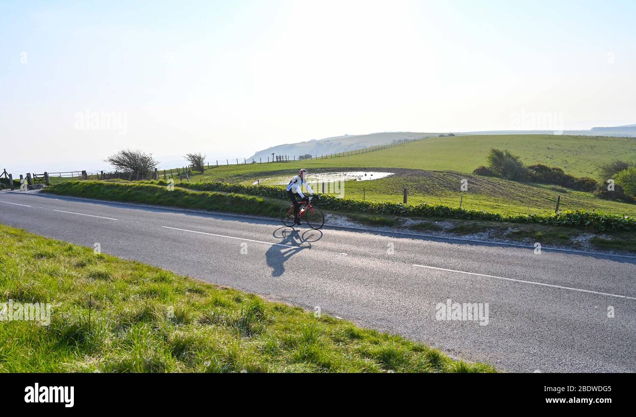 Brighton UK 10. April 2020 - EIN einstrallender Radfahrer in Ditchling Beacon ein bekannter Schönheitsort entlang des South Downs Way in der Nähe von Brighton, wo die Polizei den Parkplatz geschlossen hat. Die Regierung hat der Öffentlichkeit gesagt, nicht über das Osterwochenende zu gehen, trotz der Vorhersage gutes Wetter während der Coronavirus COVID-19 Pandemie-Krise . Quelle: Simon Dack / Alamy Live News Stockfoto