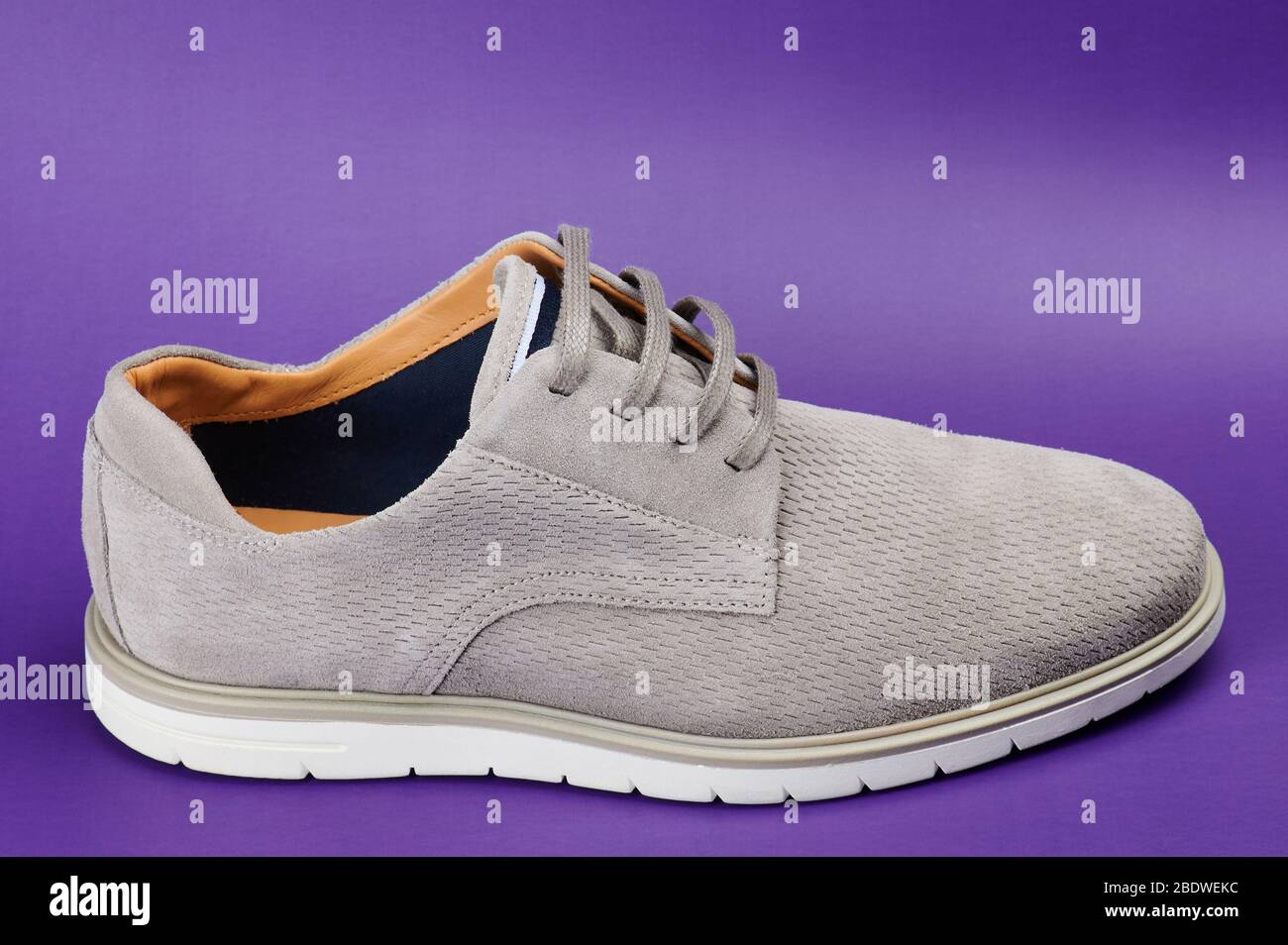Grau casual Mann Schuh Seitenansicht isoliert auf lila Hintergrund Stockfoto