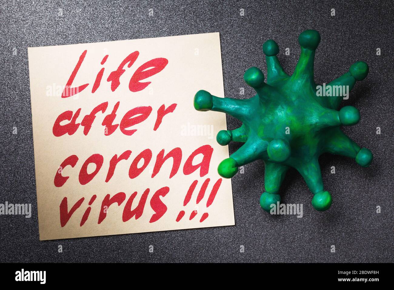 Hinweis mit Text und Spielzeug Mikrobe, Draufsicht. Das Konzept des Lebens nach dem Coronavirus Stockfoto