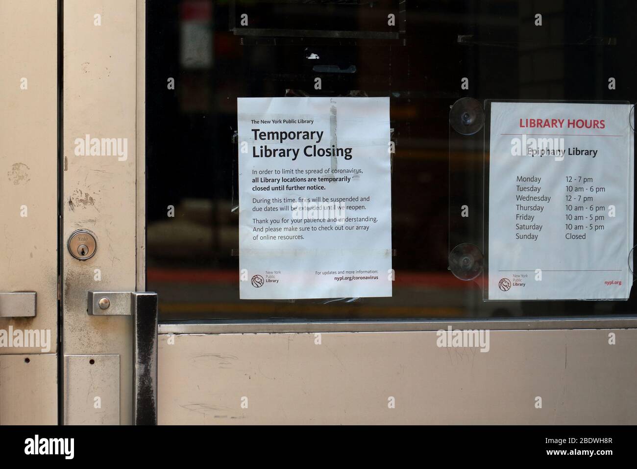 Ein Schild an einer NYPL New York Public Library Zweigstelle, auf dem steht, dass die Bibliothek wegen der COVID-19-Pandemie vorübergehend geschlossen wird. Stockfoto