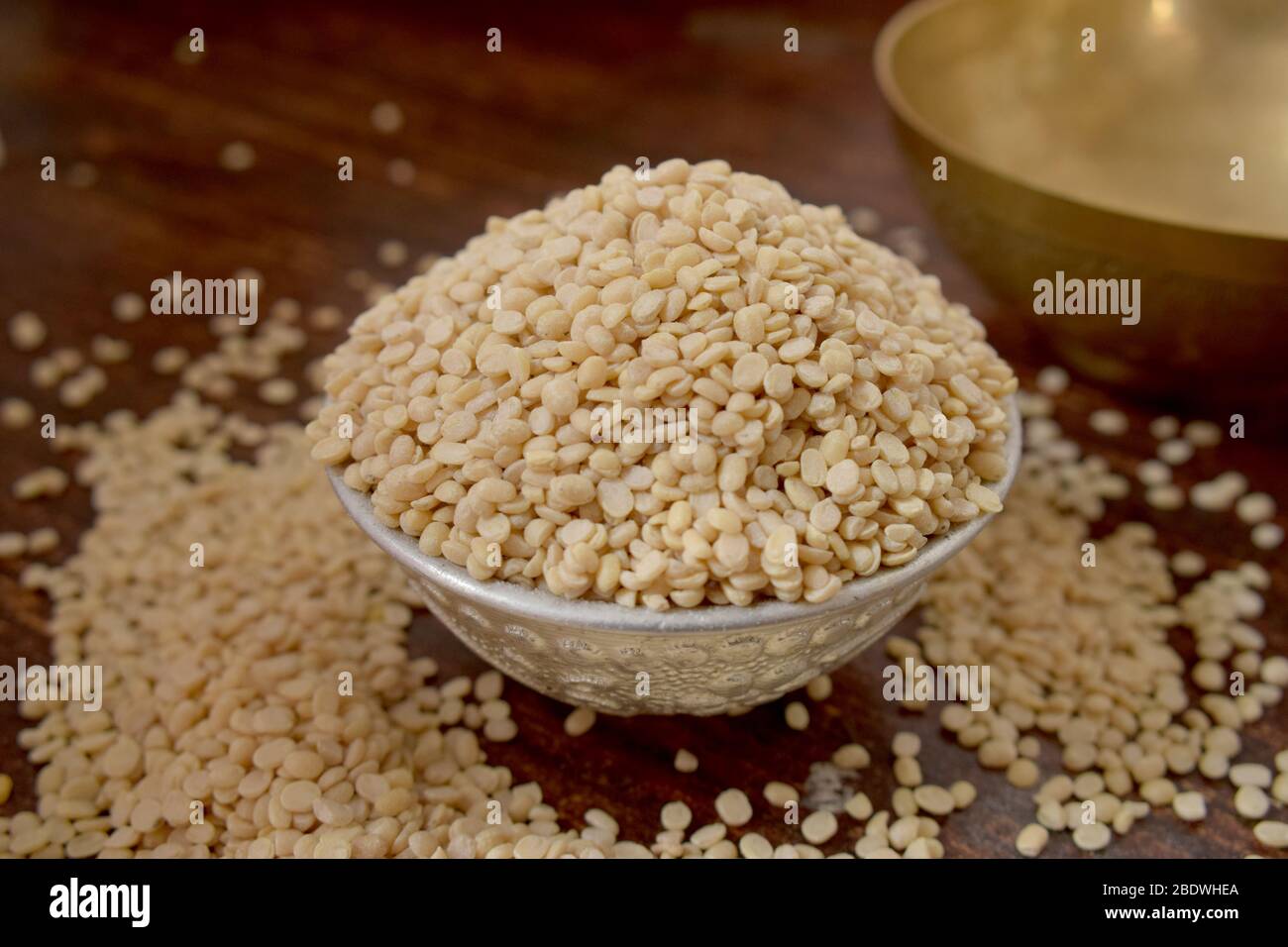 Split White Urad Dal. Vigna mungo Bohnen in einer Silberschale auf einem hölzernen alten Tisch. Rustikaler Stil Stockfoto