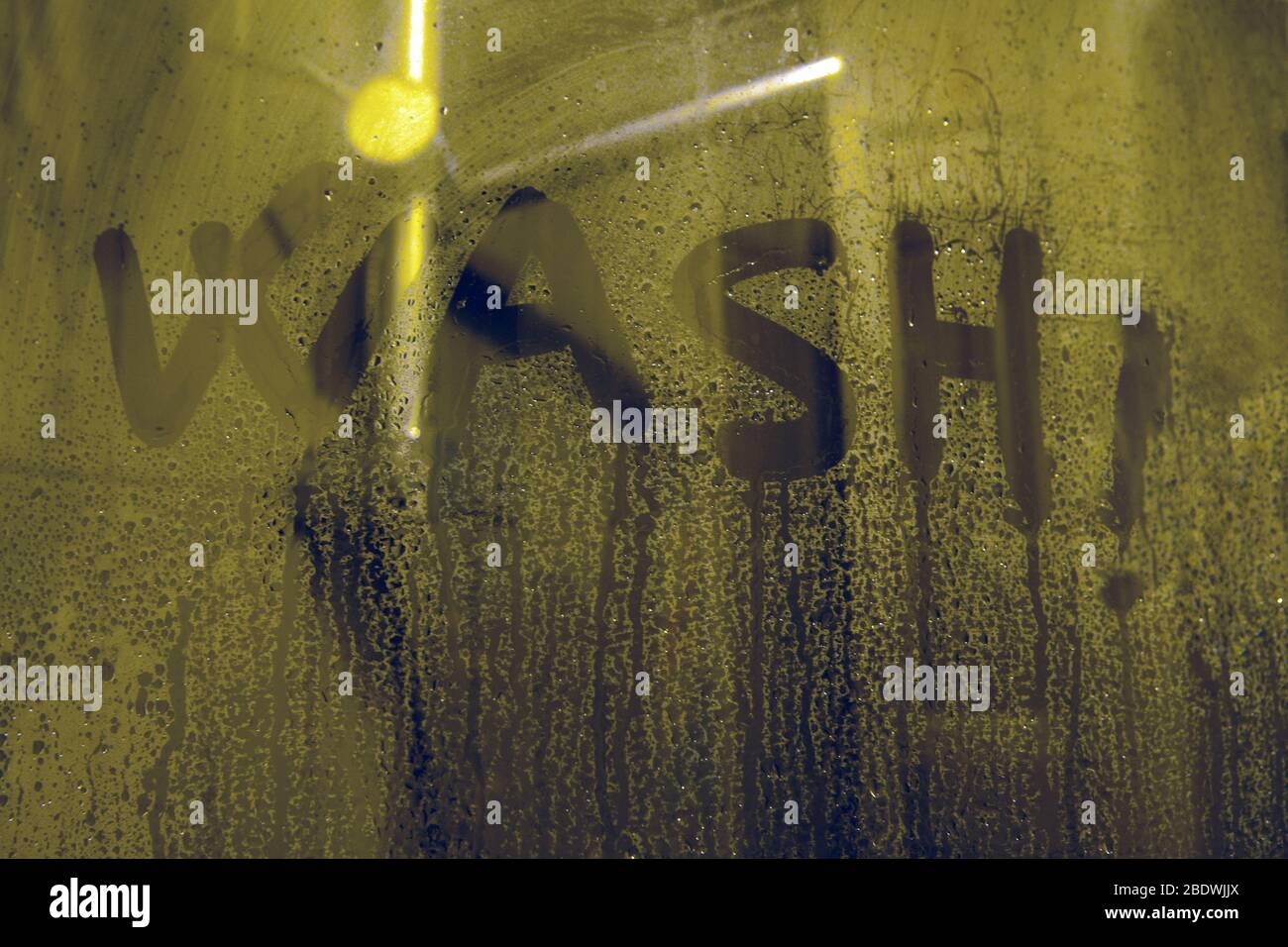 WASCHEN Sie Buchstaben auf der Dusche Glas-handgeschriebenen Schriftzug auf grauen Stuface mit Wassertropfen geschrieben.die Beschriftung auf dem Seifenglas - waschen. Stockfoto